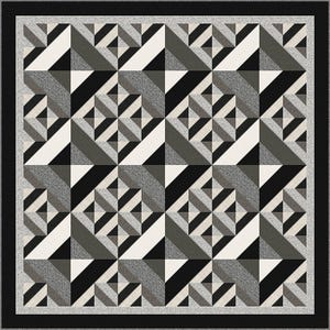 May include: A square quilt featuring a repeating geometric pattern of triangles and squares in shades of black, white, and gray. The design includes textured gray fabric blocks arranged in a grid, framed by a solid black border and a light gray edge.