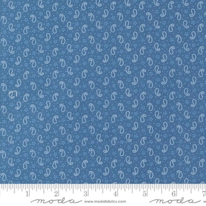 May include: A blue fabric with a white paisley pattern. The fabric is measured in inches with a ruler at the bottom of the image. The ruler has the word "moda" printed on it.