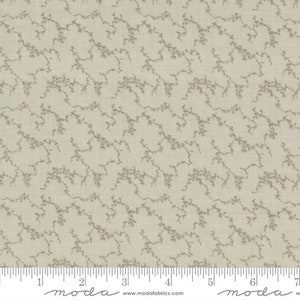 May include: A beige fabric with a subtle, repeating pattern of light brown, branching lines. The fabric is textured and has a slight sheen. The fabric is measured in inches with a ruler that reads "moda" at the 2-inch mark and the 6-inch mark.