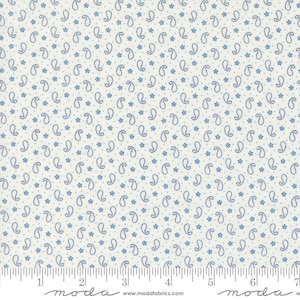 May include: White fabric with a repeating pattern of small blue paisley shapes and tiny blue dots. The fabric is measured with a ruler that reads "moda" at both ends.