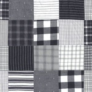 May include: A black and white patchwork quilt with a variety of plaid patterns. The quilt is made up of squares of different sizes and colors.