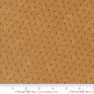 May include: Close-up of a fabric with a repeating pattern of small red flowers and green leaves on a tan background. The fabric has a dotted texture and a ruler is at the bottom. The word "moda" is printed at the bottom.