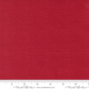 May include: Red textured fabric with a subtle woven pattern. The fabric is measured with a ruler that reads "moda" and includes the website address "www.modafabrics.com".