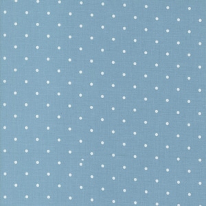 May include: A close-up of a light blue fabric with a repeating pattern of small, evenly spaced white polka dots. The fabric has a slightly textured appearance, suggesting it may be cotton or a similar material. The polka dots are consistent in size and shape.