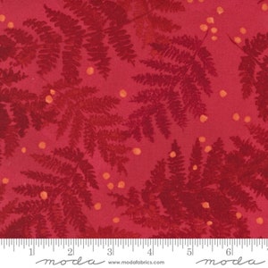 May include: Red fabric with a repeating pattern of fern leaves and small orange dots. The fabric is marked with a ruler in inches and the word "moda" appears twice.