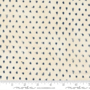 May include: A white fabric with a blue polka dot pattern. The dots are small and scattered randomly across the fabric. The fabric is textured and has a slightly rough feel.