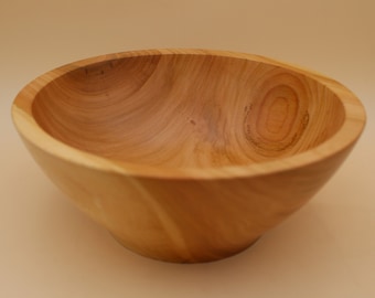 May include: A natural wood bowl with a light brown color and a smooth, rounded shape.