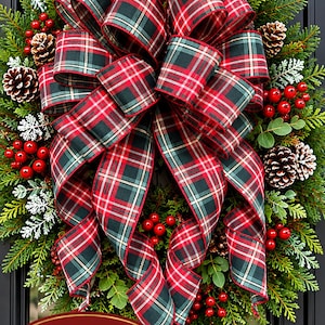 May include: A decorative bow featuring a red, dark green, and white plaid pattern with wired edges. The bow is displayed on a wreath and includes text that reads 12 x 20 inches Bow Only. The fabric has a classic tartan design with visible folds.