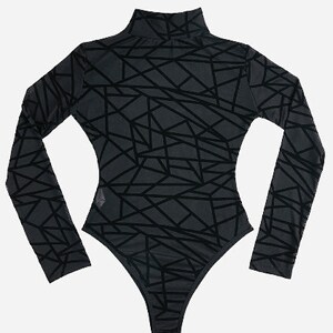 May include: Black long-sleeved bodysuit with a geometric pattern.