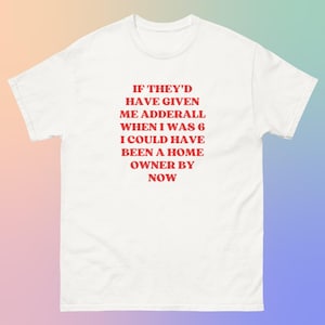Può includere: T-shirt bianco con testo rosso: "IF THEY'D HAVE GIVEN ME ADDERALL WHEN I WAS 6 I COULD HAVE BEEN A HOME OWNER BY NOW." La maglietta è uno stile casual a maniche corte.