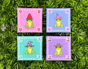 tiny paintings of frogs with silly hats - strawberry, flower, cowboy and wizard!