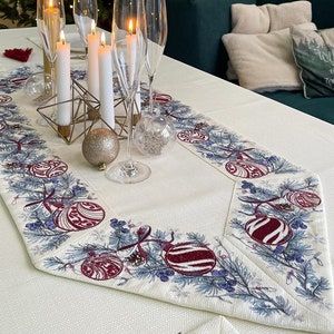Puede incluir: Una mesa navide&ntilde;a festiva con un &aacute;rbol decorado al fondo. La mesa est&aacute; decorada con copas de champ&aacute;n, velas encendidas y un camino de mesa decorativo con adornos navide&ntilde;os. Un portavelas geom&eacute;trico dorado y un adorno brillante realzan el ambiente festivo.