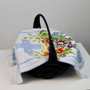 Easter basket cover with blue cross embroidery and spring floral design