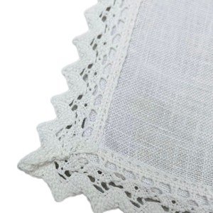 May include: White linen tablecloth with a delicate white crochet lace border.