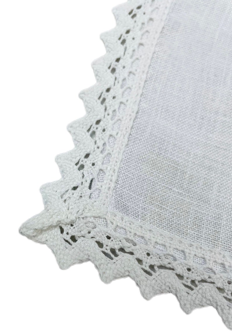 May include: White linen tablecloth with a delicate white crochet lace border.