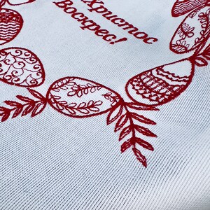 May include: White fabric with red embroidered Easter eggs and the text "Хриcтоc Воскрес!" which translates to "Christ is Risen!" in English.