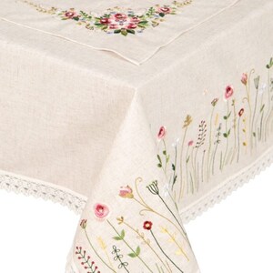 May include: A beige linen tablecloth with embroidered floral designs. The tablecloth has a delicate lace trim and features a floral bouquet in the corner.