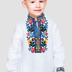 May include: A white long-sleeved shirt with colorful embroidered flowers on the front. The shirt has a blue tassel and a white collar.