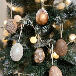 Decorative hand painted egg ornaments with botanical patterns, Symbolic hanging accents for neutral home styling and seasonal interior decor