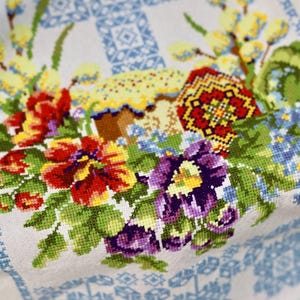 Easter basket cover with blue cross embroidery and spring floral design