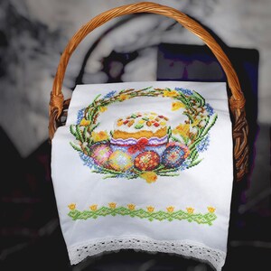 Może przedstawiać: Biały ceramiczny kubek z czarnym uchwytem i napisem "But First, Coffee" czarną, pogrubioną czcionką. Kubek stoi na białej powierzchni. Kubek ma około 10 cm wysokości.