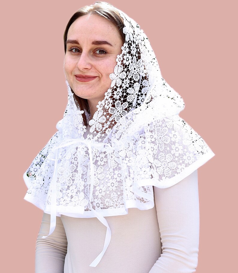 May include: White lace mantilla with a scalloped edge and a bow tie. The mantilla is worn over the head and shoulders.