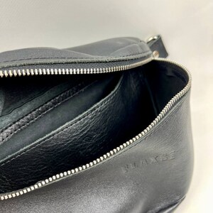 May include: Black leather zippered pouch with a silver zipper and the word "WAKESE" embossed on the bottom.
