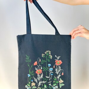 Black canvas tote with embroidered wildflowers, poppies and cornflowers, reusable cotton shoulder bag for shopping, books, market and gifts