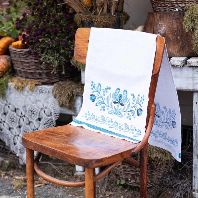 White linen towel with blue floral embroidery