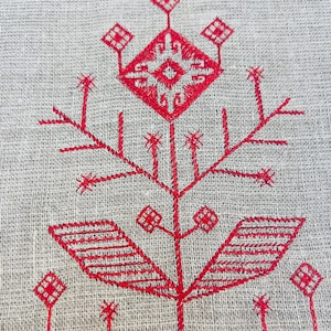 K&ouml;nnte beinhalten: Rote gestickte Blumenmuster auf einem nat&uuml;rlichen Leinenstoff. Das Design zeigt eine stilisierte Blume mit Bl&auml;ttern und Stielen.