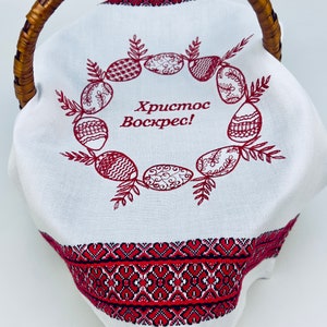 May include: White fabric Easter basket with a red embroidered wreath of eggs and the text "Христос Воскрес!" (Christ is Risen!). The basket has a brown wicker handle.