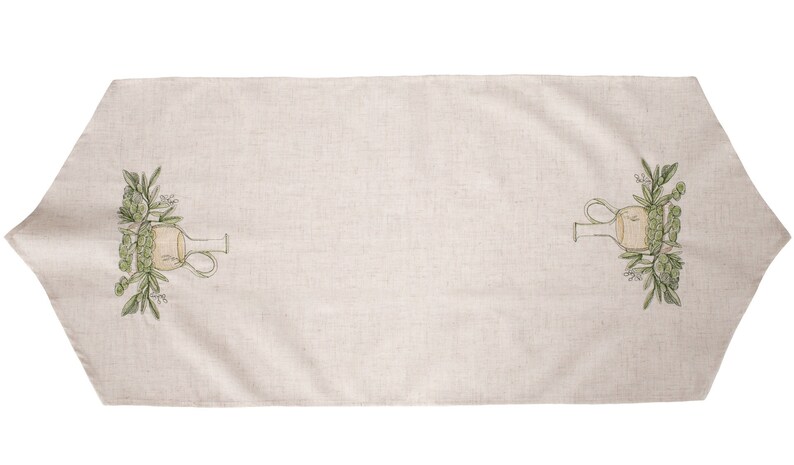 May include: A beige linen table runner with a green and yellow embroidered design of a pitcher and olive branches on each end.