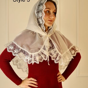 May include: A sheer, ivory-colored cape with a hood and floral lace trim. The cape is worn over a burgundy-colored dress. The text "Style 5" is in the upper left corner.