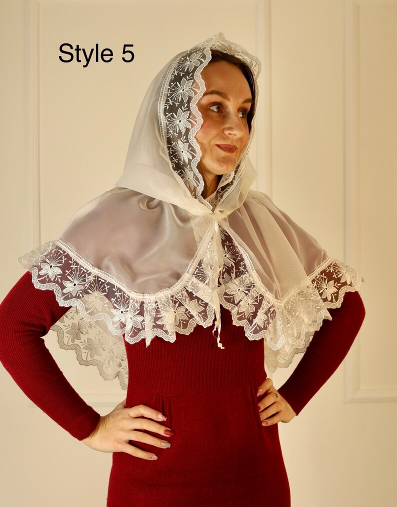 May include: A sheer, ivory-colored cape with a hood and floral lace trim. The cape is worn over a burgundy-colored dress. The text "Style 5" is in the upper left corner.