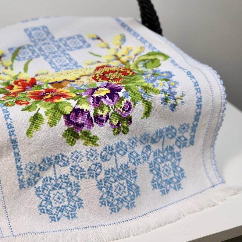 Easter basket cover with blue cross embroidery and spring floral design