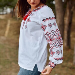 White Folk Embroidered Blouse with Red and Black Geometric Patterns – Long Sleeve Traditional Peasant Shirt for Women with Tassel Tie Detail