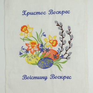 May include: White embroidered tea towel with a floral design of daffodils, willow branches, and bluebells. The text "Христос Воскрес" and "Воистину Воскрес" is embroidered in blue thread.