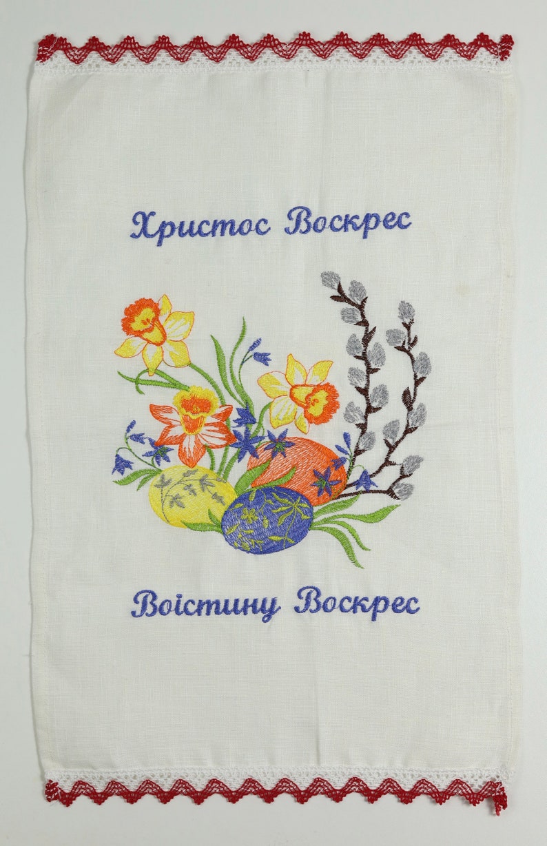 May include: White embroidered tea towel with a floral design of daffodils, willow branches, and bluebells. The text "Христос Воскрес" and "Воистину Воскрес" is embroidered in blue thread.