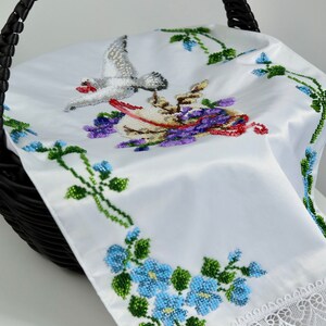 May include: White satin Easter basket liner featuring a beaded design of a dove and flowers. The liner has a lace trim and is ideal for adding a touch of elegance to your Easter basket.