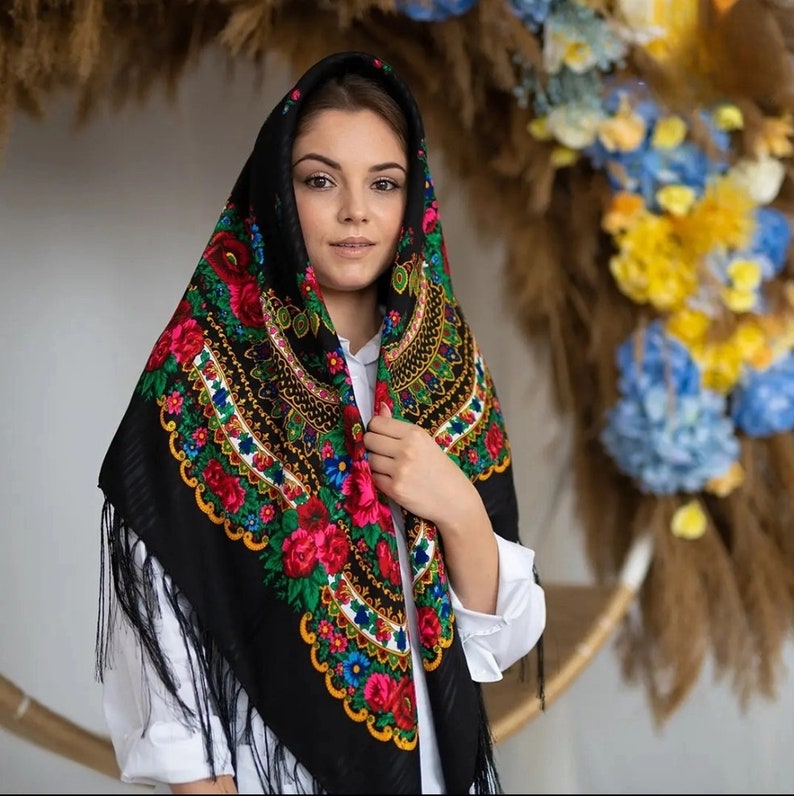 Puede incluir: Un pa&ntilde;uelo negro con bordados florales coloridos y flecos. El pa&ntilde;uelo lo lleva una persona con el pelo largo y casta&ntilde;o.
