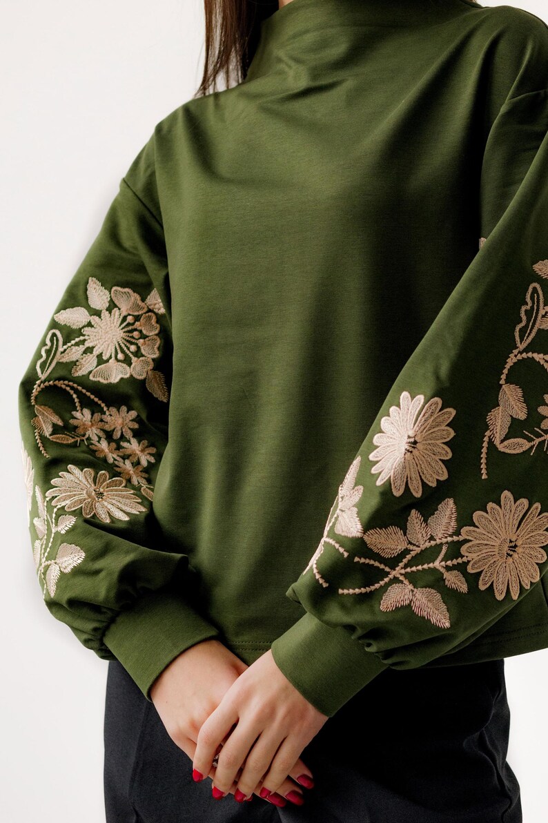 Green sweatshirt with white flower embroidery