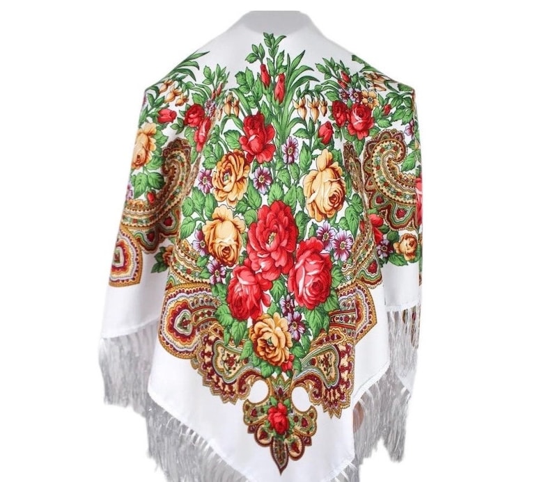 Peut inclure: &Eacute;charpe en coton blanc avec un motif floral en rouge, jaune et vert. L'&eacute;charpe a une bordure &agrave; franges et un motif paisley.