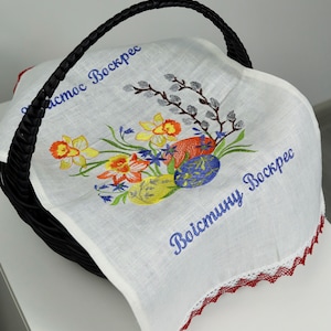 Puede incluir: Forro de cesta de Pascua de lino blanco con ribete de encaje rojo. El forro presenta flores bordadas, huevos y el texto "Христос Воскрес" y "Воистину Воскрес".