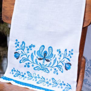 White linen towel with blue floral embroidery