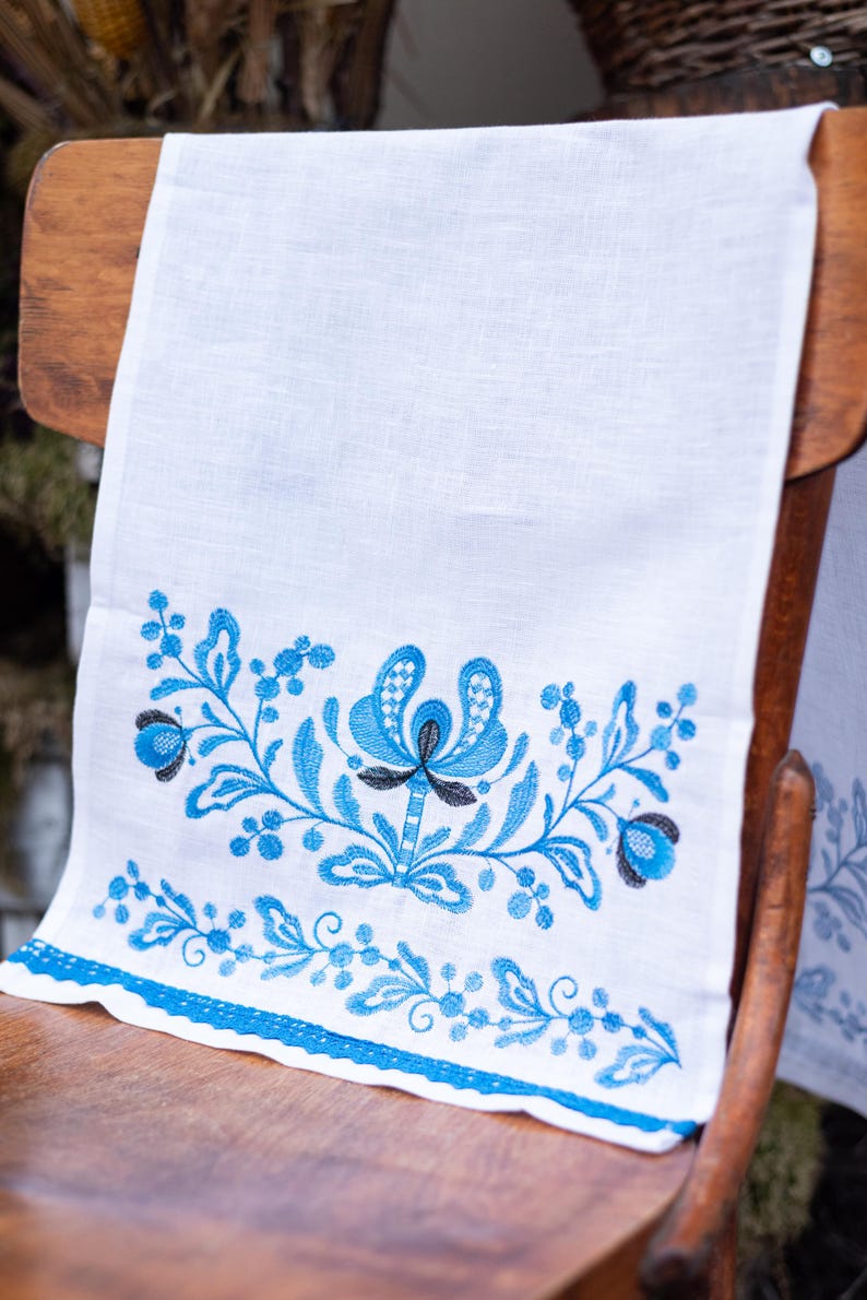 White linen towel with blue floral embroidery
