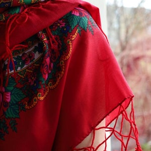 Puede incluir: Un chal rojo con un patr&oacute;n floral y flecos. El chal est&aacute; hecho de una tela suave y ligera y tiene un dise&ntilde;o tradicional.