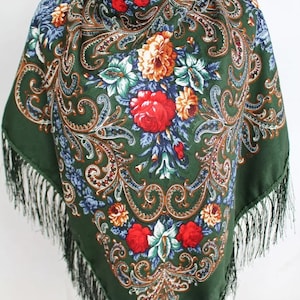 May include: A green silk scarf with a floral pattern and fringe. The pattern features red, orange, yellow, blue, and green flowers on a dark green background.
