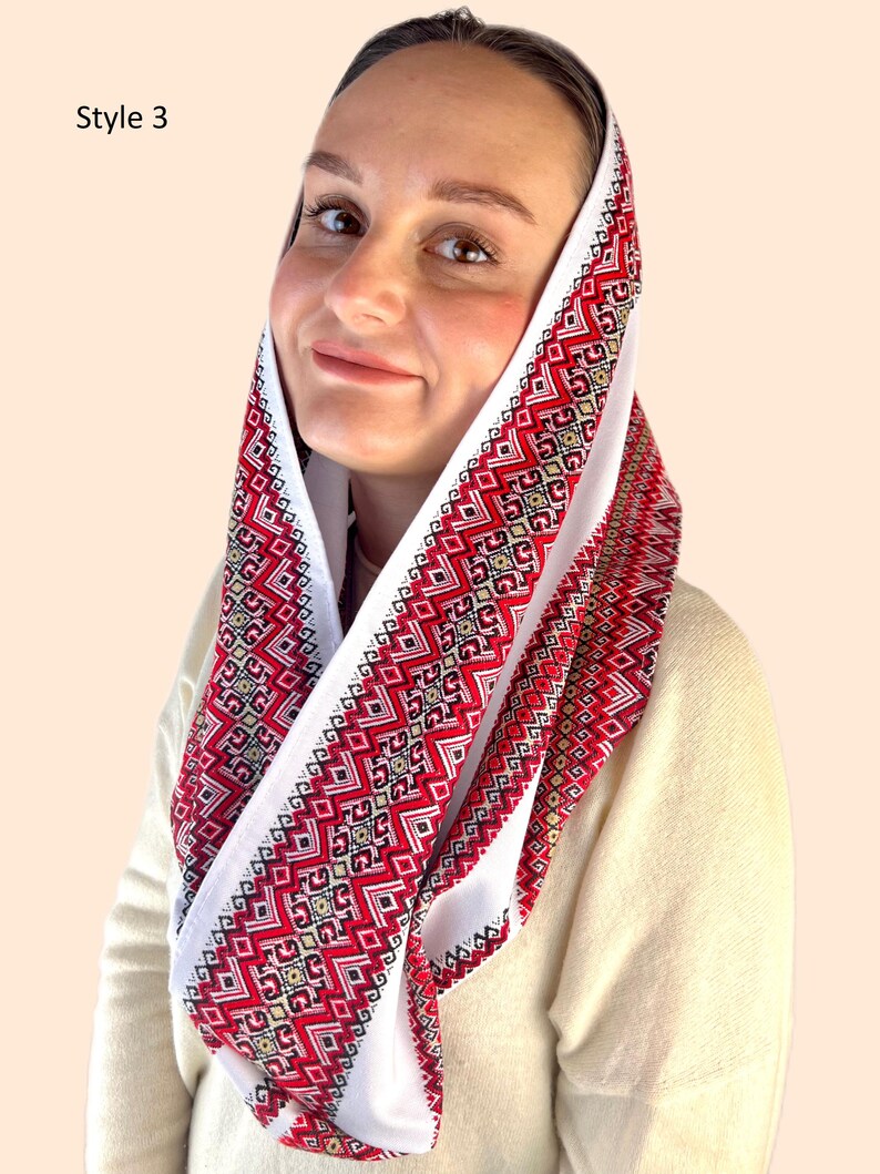 May include: White head scarf with red and gold embroidered geometric patterns. The scarf is folded and worn around the head. Style 3.