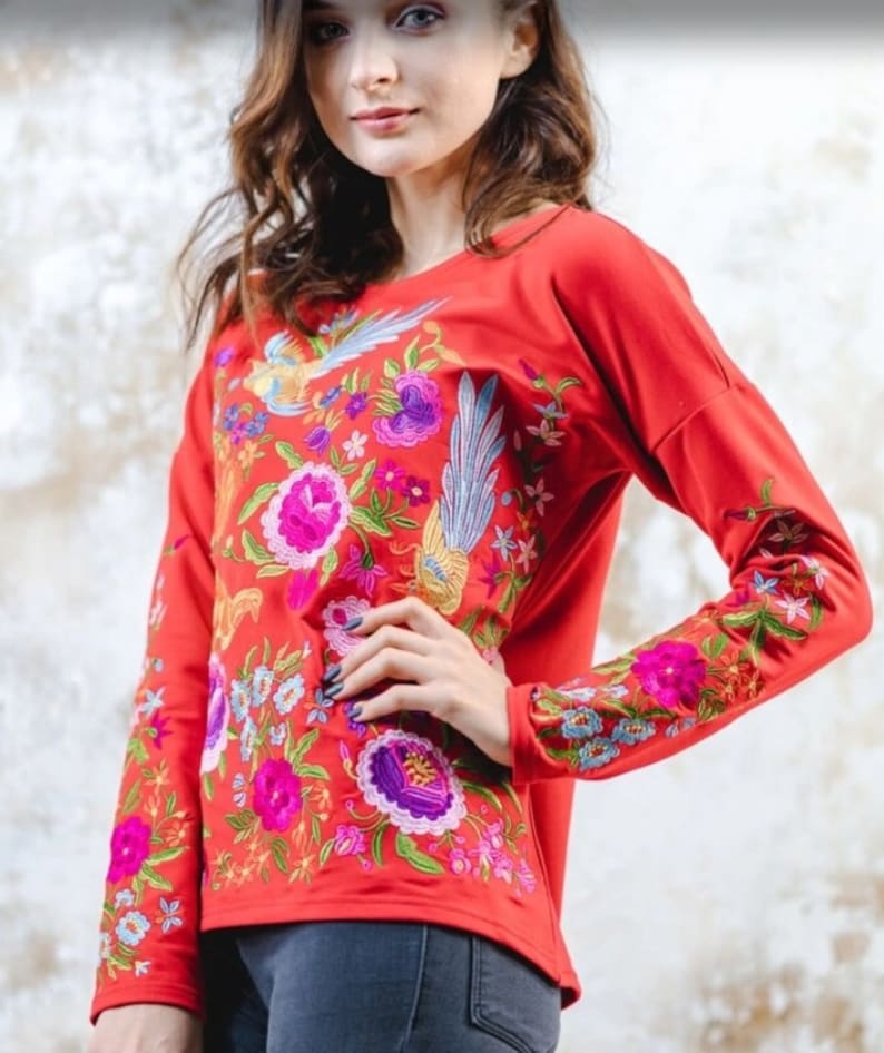 Puede incluir: Camiseta roja de manga larga con bordado floral y de p&aacute;jaros de colores.