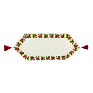 May include: Cream-colored table runner with a detailed embroidered border of red berries and green leaves. The runner has burgundy tassels at each end. A decorative textile for the dining room or kitchen.